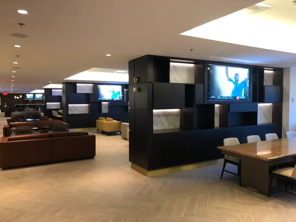 Media Wall Casework | Warm Home Inc Luxury common lounge with matte black media wall units, marble-backed cubbies, and herringbone floors by Warm Home Inc