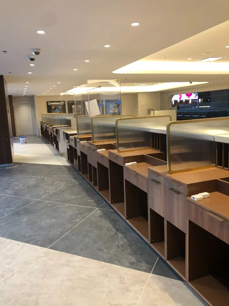 Custom Office Workstation Millwork | Warm Home Inc Row of custom wood office workstations with cubbies, drawers, and glass privacy screens by Warm Home Inc